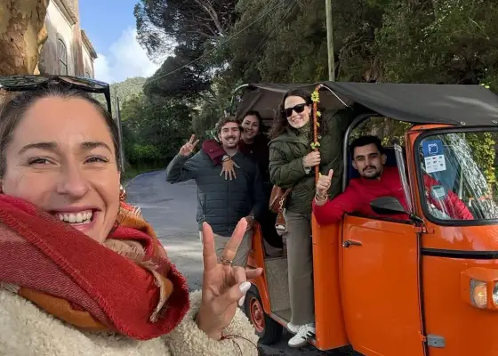 Eine YourTuk-Reiseleiterin und Gäste neben einem orangefarbenen Tuk-Tuk